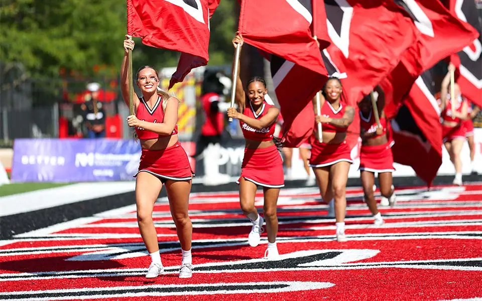 cheerleaders running with flags