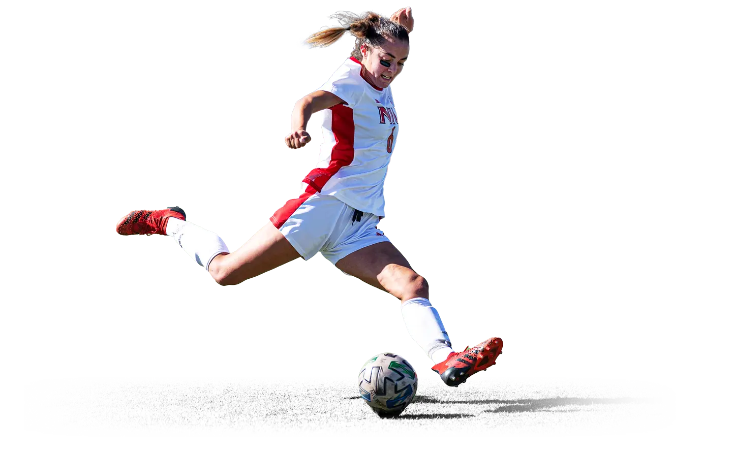 Women's soccer player kicking the ball